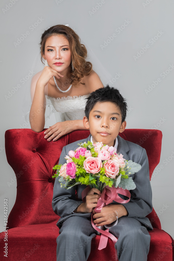 Bride sitting with son, he holding a bouquet.. Bride sitting with son, he holding a bouquet..