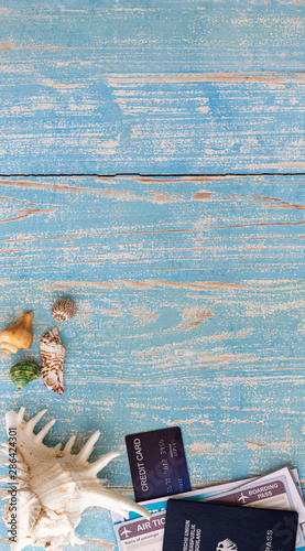 Summer holiday theme background setting with different sea shell, passport and credit card in blue ocean wood, Copy space for text