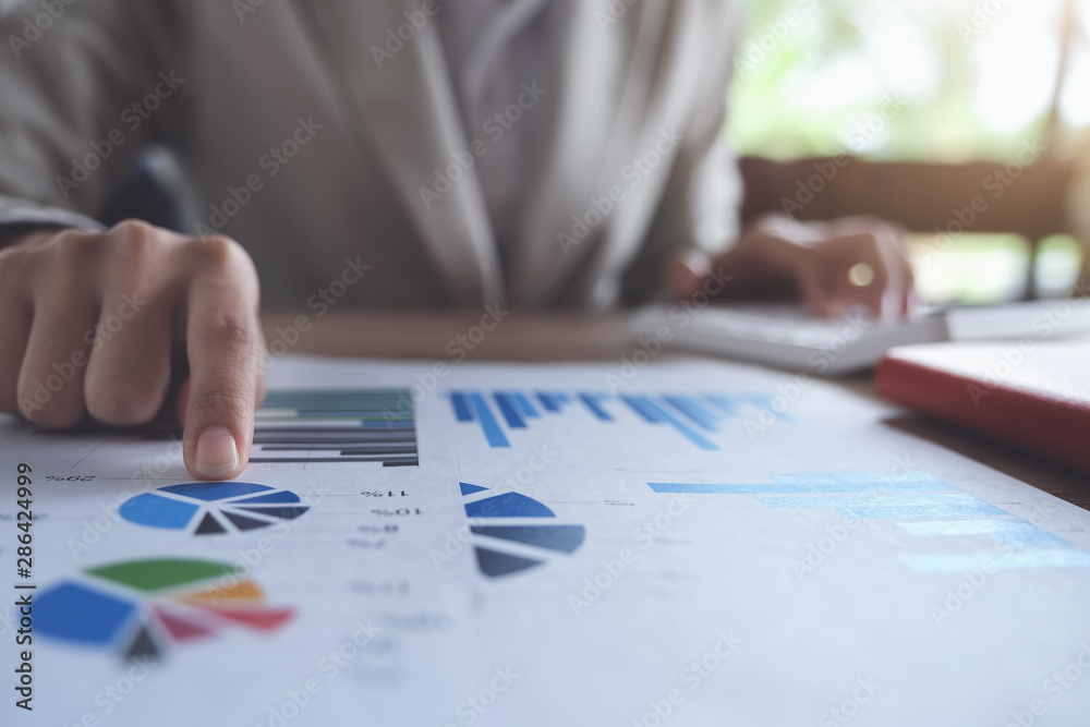 Business accounting concept, Business man pointing graph chart and using calculator to calculating budget and loan paper in office. Business accounting concept, Business man pointing graph chart and using calculator to calculating budget and loan paper in office.