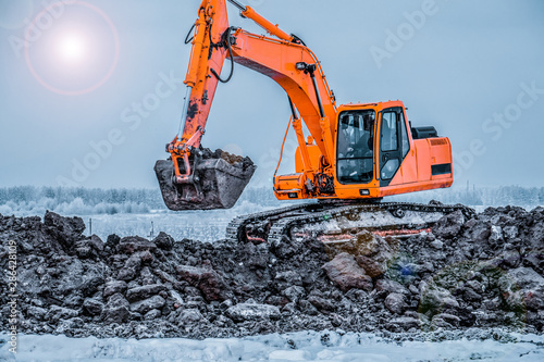 Excavators and heavy machinery in the works of stone movement in a quarry stone extraction for its transformation into gravel. Close-up of a construction site excavator.