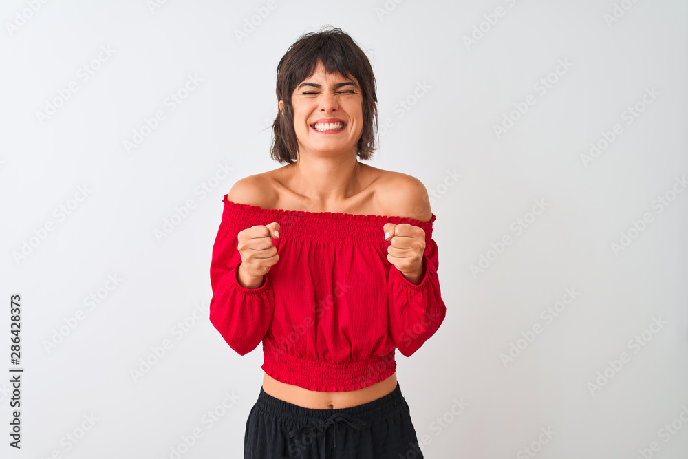Young beautiful woman wearing red summer t-shirt standing over isolated white background excited for success with arms raised and eyes closed celebrating victory smiling. Winner concept. Young beautiful woman wearing red summer t-shirt standing over isolated white background excited for success with arms raised and eyes closed celebrating victory smiling. Winner concept.