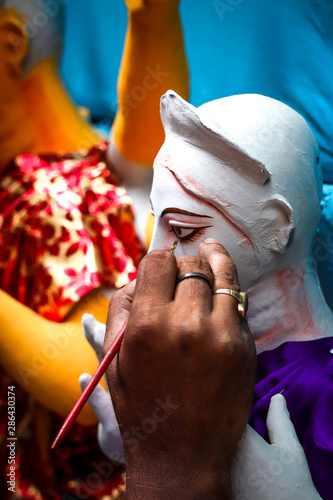 Kolkata; India - Asia; An artist gives final touches to idol of hindu Goddess Durga in workshop made of Plaster of Paris Clay at Kumortuli for upcomming Durgapuja festival 3 photo