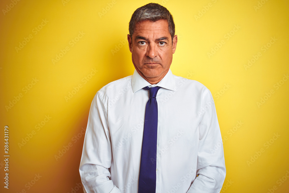 Handsome middle age businessman standing over isolated yellow background skeptic and nervous, frowning upset because of problem. Negative person. Handsome middle age businessman standing over isolated yellow background skeptic and nervous, frowning upset because of problem. Negative person.