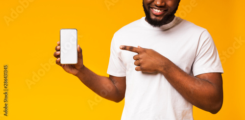 Man holding smartphone with blank screen and pointing on it
