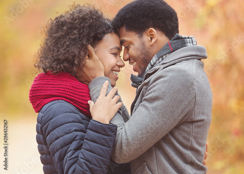Tender afro couple bonding to each other, touching foreheads