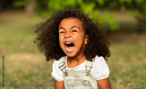 Little girl screaming over natural summer background