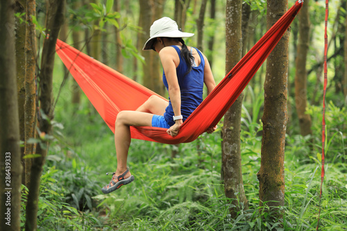 Woman relaxing in hammock in tropical rainforest