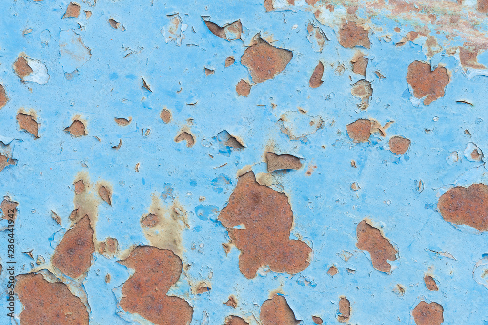 Close-up of a weathered and worn sheet metal plate painted in light blue.  Paint is partly peeled off revealing rusty metal. High resolution full  frame abstract background. Copy space. Stock Photo