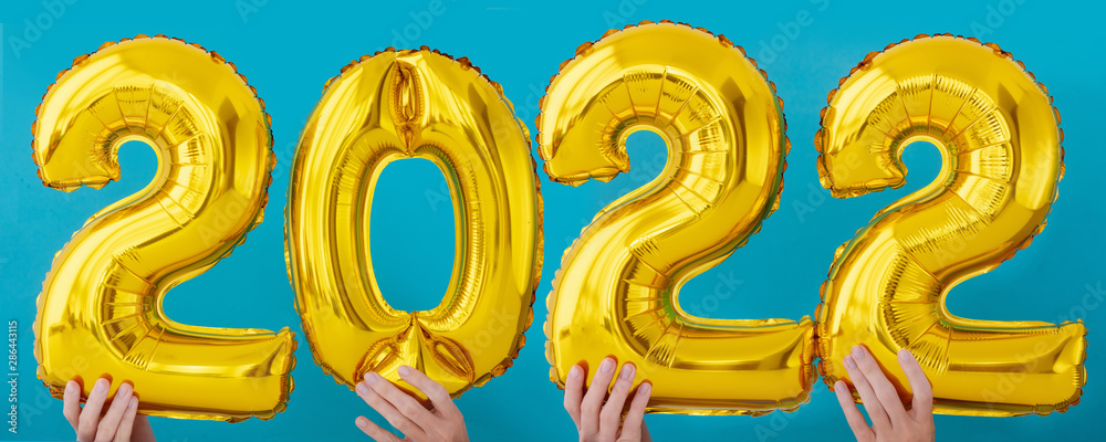 Gold foil number two thousand and twenty two 2022 celebration balloon on blue background Gold foil number two thousand and twenty two 2022 celebration balloon on blue background