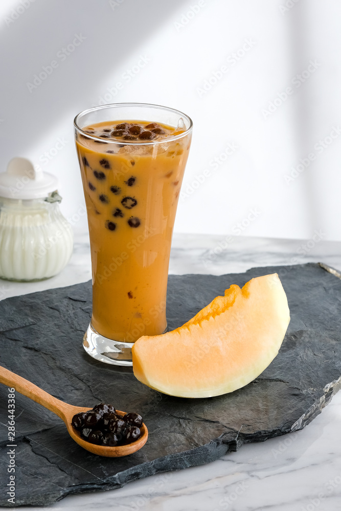 Bubble milk tea with milk and bubble topping for tea or other beverage on the wood table with copy-space for text. Bubble milk tea with milk and bubble topping for tea or other beverage on the wood table with copy-space for text.
