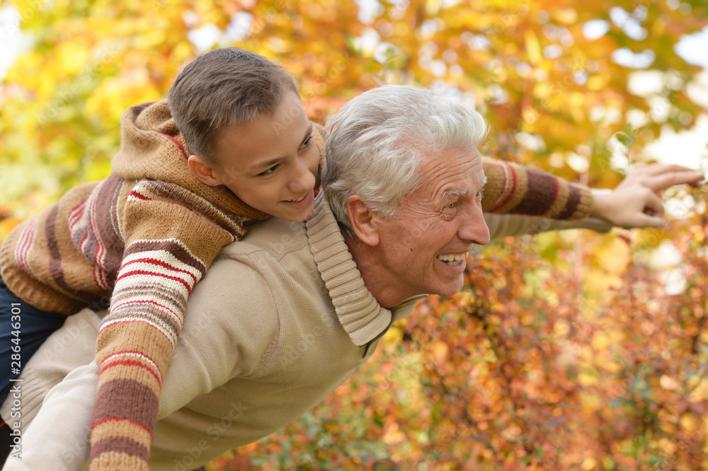 Portrait of grandfather and grandson hugging in park Portrait of grandfather and grandson hugging in park