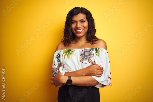 Transsexual transgender woman wearing summer t-shirt over isolated yellow background happy face smiling with crossed arms looking at the camera. Positive person. photo