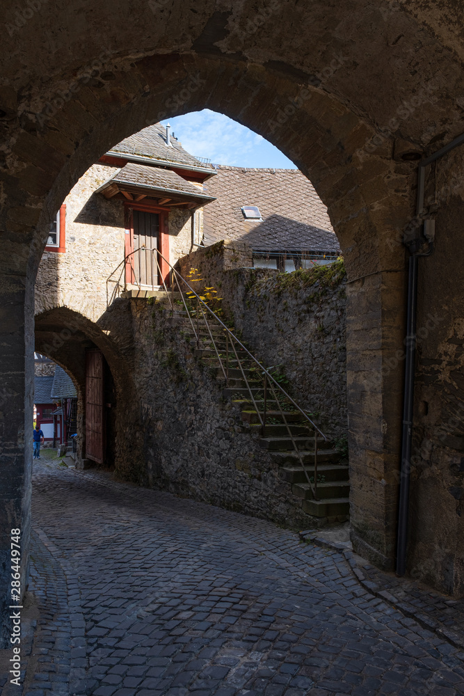 Blick durch einen Durchgang auf eine alte Steintreppe in Braunfels/Deutschland