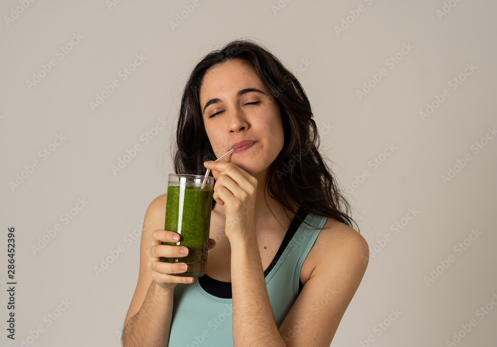 Happy beautiful fit sport woman smiling and drinking healthy fresh vegetable detox smoothie Happy beautiful fit sport woman smiling and drinking healthy fresh vegetable detox smoothie