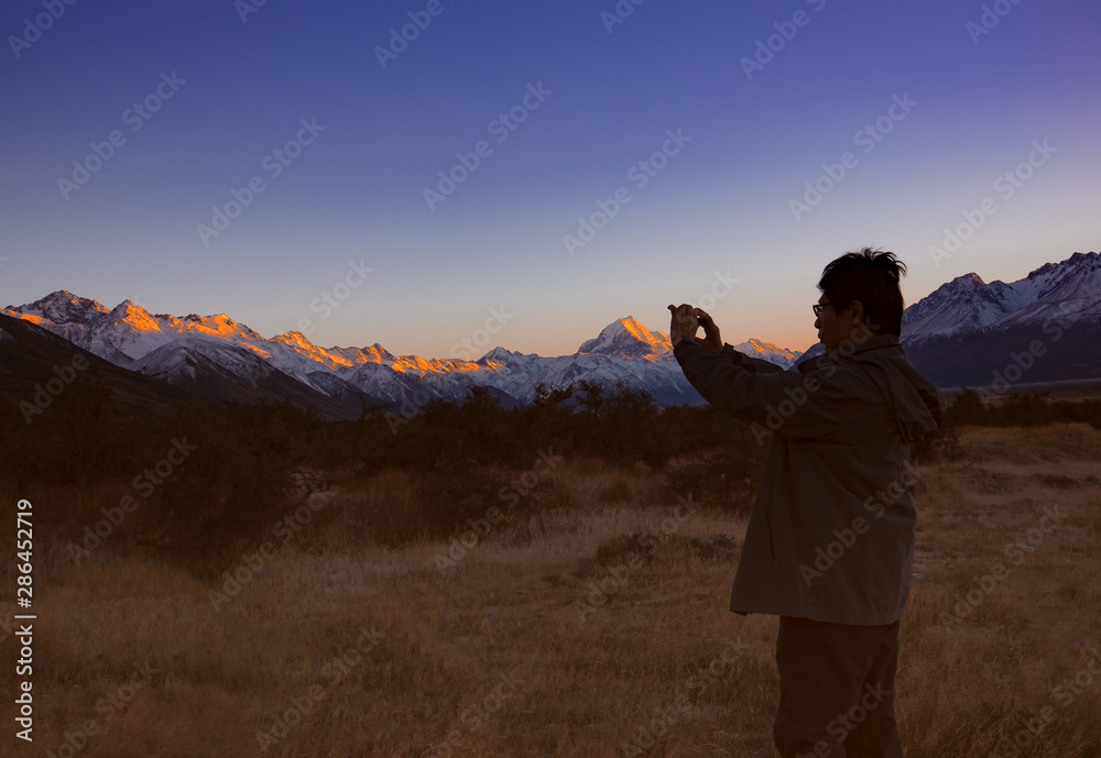 Happy and relax time with smartphone taking picture  in the morning at Mount Cook National Park, South Island, New Zealand - obrazy, fototapety, plakaty 
