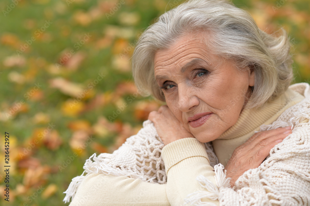 Close up portrait of sad senior woman in autumn park Close up portrait of sad senior woman in autumn park