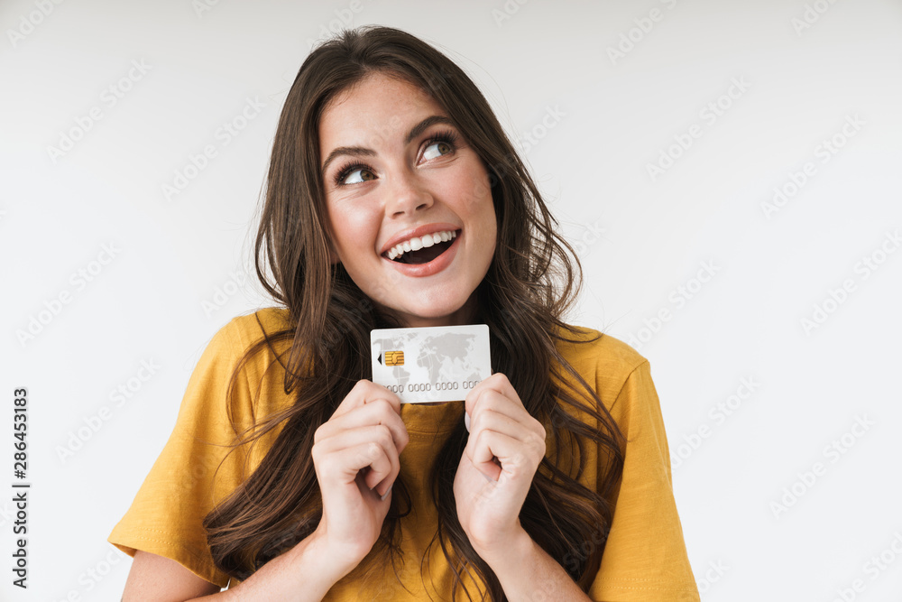 Image of caucasian brunette woman wearing casual clothes smiling and holding credit card