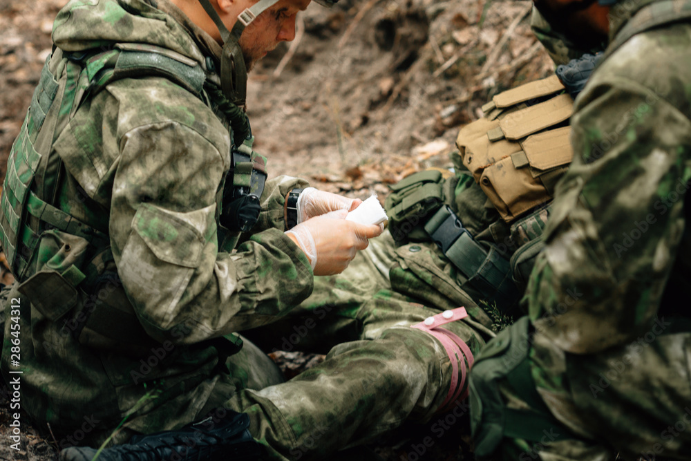 Bandaging a wounded soldier. A group of soldiers in defense of their positions.