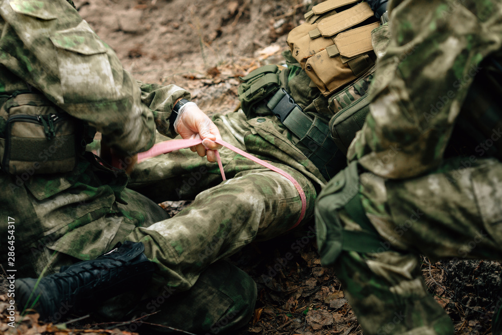 Bandaging a wounded soldier. A group of soldiers in defense of their positions.