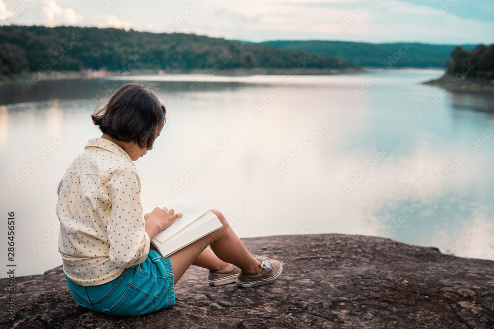 Asian girl reading a book during hobby time.