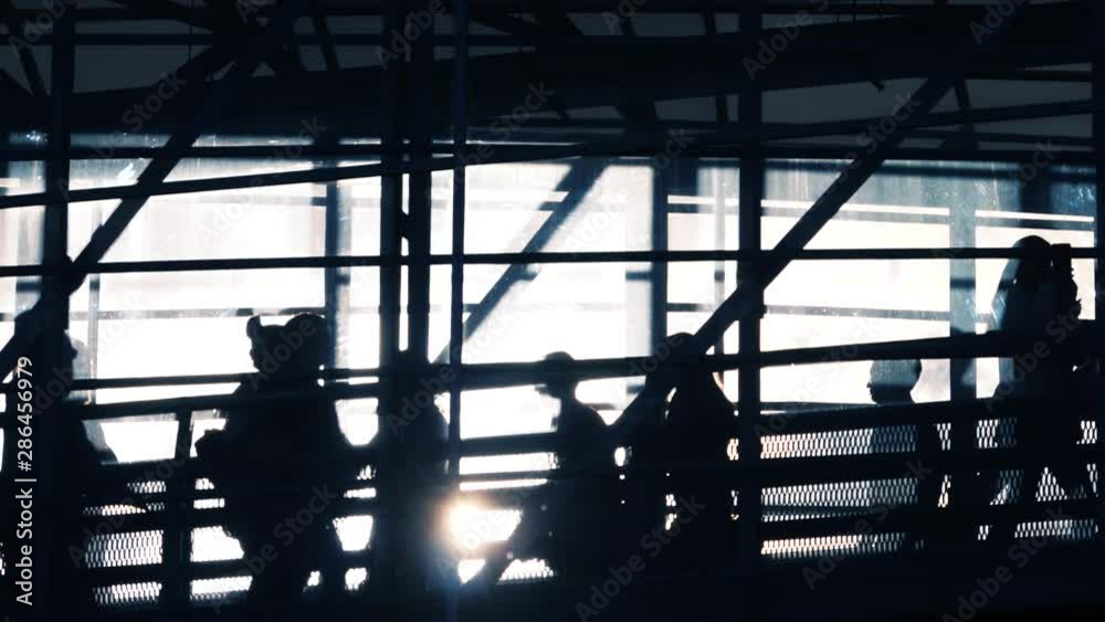 Crowd silhouettes on a pedestrian bridge slow motion Crowd silhouettes on a pedestrian bridge slow motion