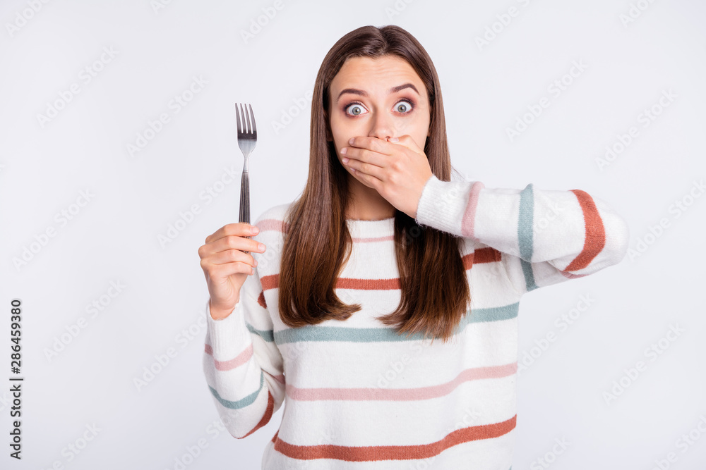 Crazy lady hiding mouth with arm remind herself about taboo on night eating wear striped pullover isolated white background Crazy lady hiding mouth with arm remind herself about taboo on night eating wear striped pullover isolated white background