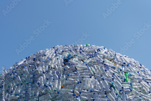 semicircular mountain of plastic waste, plastic bottles with a beautiful blue background