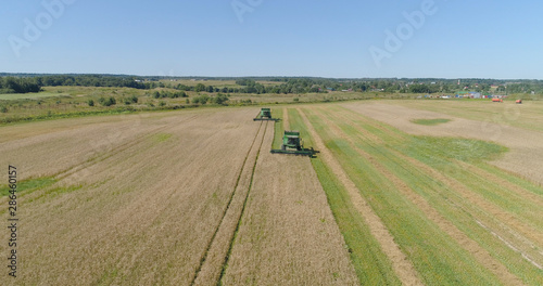 Combine harvester at work harvesting field wheat. Aerial view Combine harvester mows ripe spikelets, barley, rye. Combine harvester harvest ripe wheat on a farm.