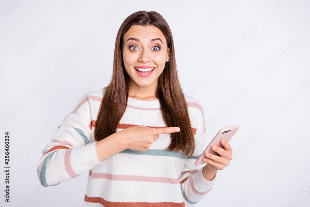 Pretty lady with telephone in hands indicating finger on device screen wear striped pullover isolated white background Pretty lady with telephone in hands indicating finger on device screen wear striped pullover isolated white background