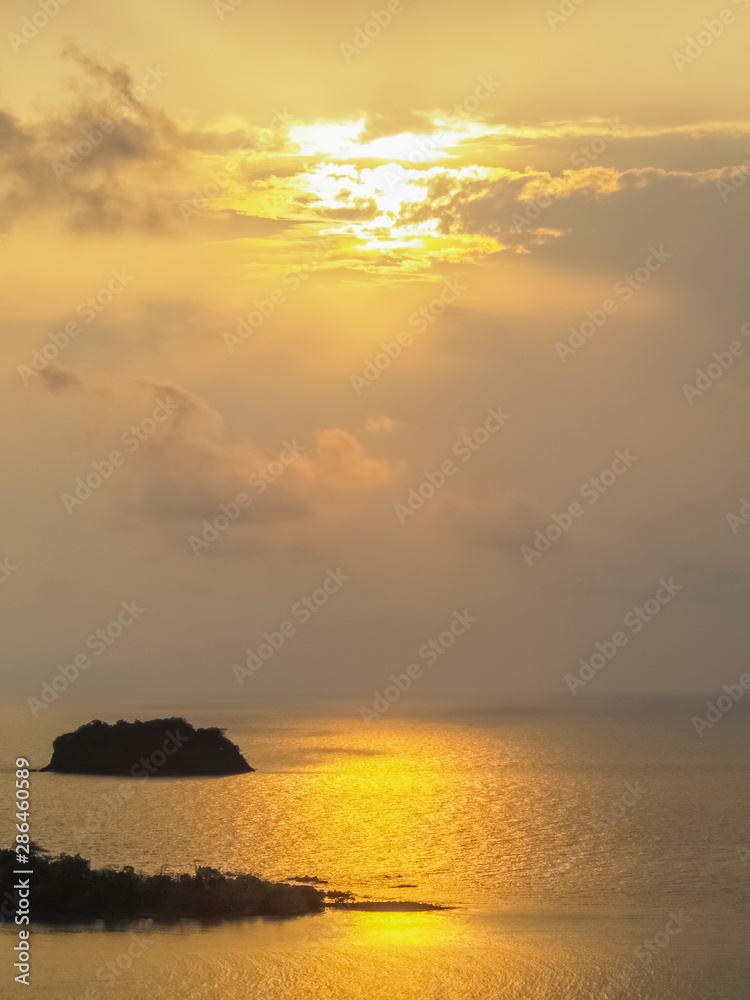 ew seaside evening of small island in the sea with yellow sun light background, sunset at Kai Bae View Point, Koh Chang, Trat Province, Thailand.