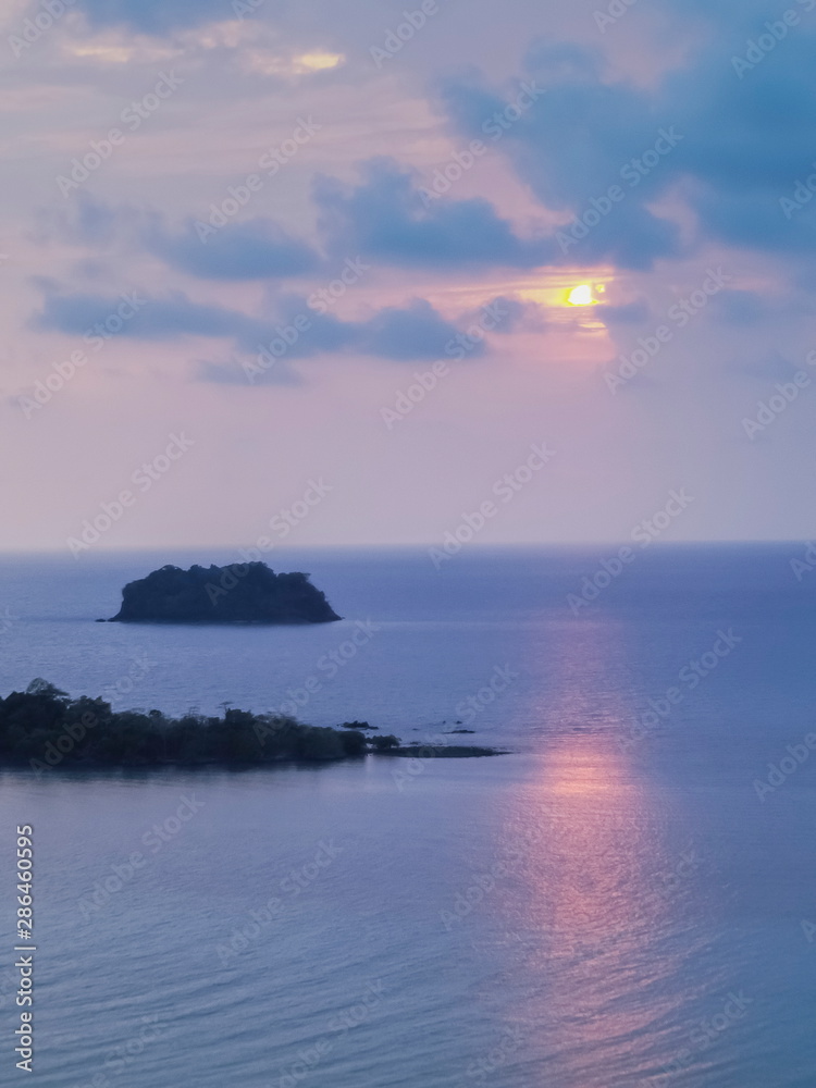 view seaside evening of small island in the sea with orange sun light and cloudy sky background, sunset at Kai Bae View Point, Koh Chang, Trat Province, Thailand.