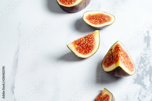 Close up view on Fresh figs. Exotic fruit. Mock up with Sliced fig on craft paper on marble background. Copy space. Selective focus. Food photo background.
