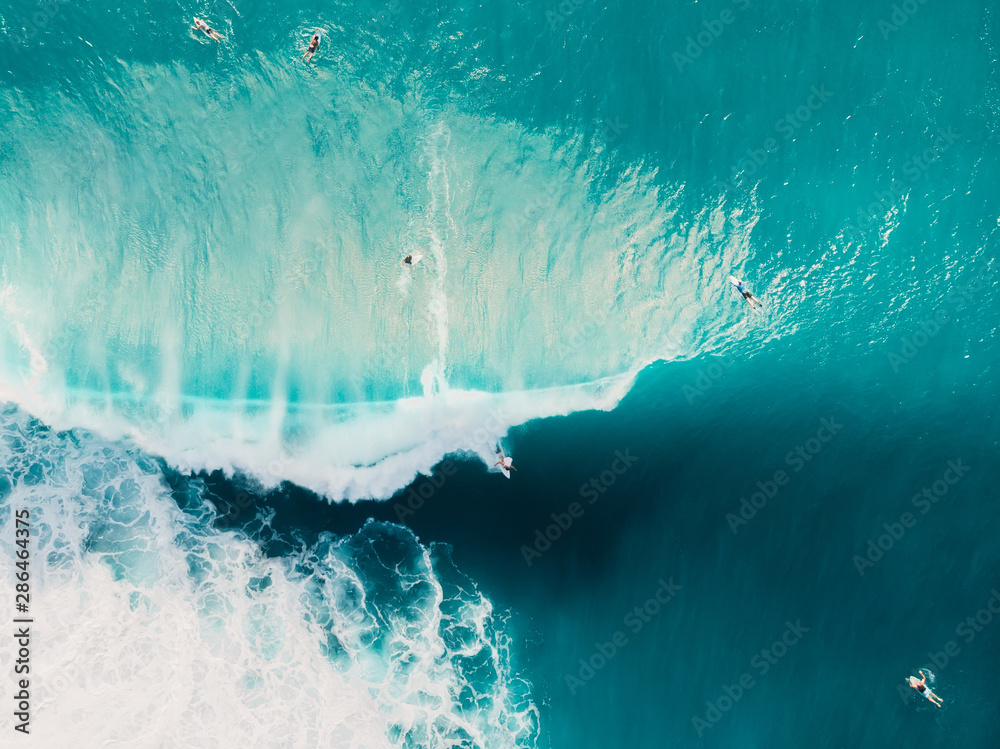 Aerial view of surfing at barrel waves. Blue wave in ocean and surfers - obrazy, fototapety, plakaty 