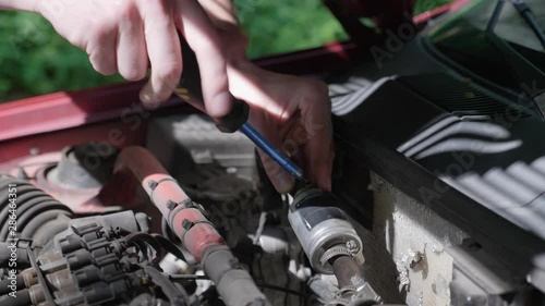 Wallpaper Mural Close-up of the hands of a man who independently replaces the Lpg filter in his car. Young guy repairing auto in outdoor. The automobile broke down on the road. 4K footage. Torontodigital.ca