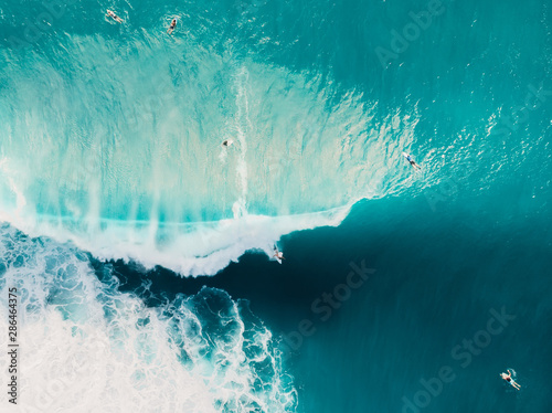 Aerial view of surfing at barrel waves. Blue wave in ocean and surfers