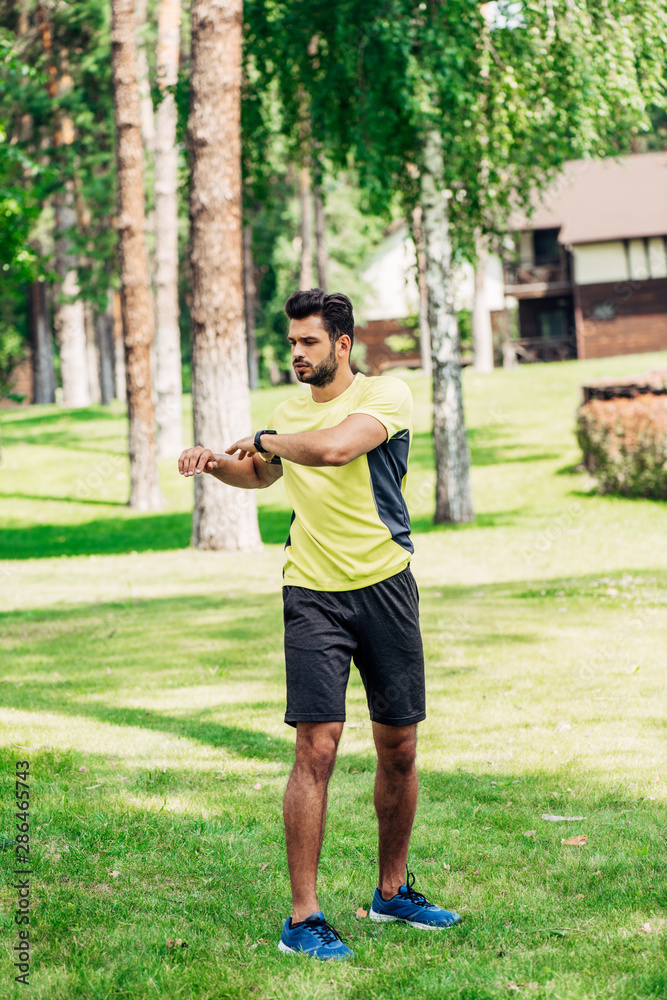 handsome young sportsman working out in park on grass handsome young sportsman working out in park on grass