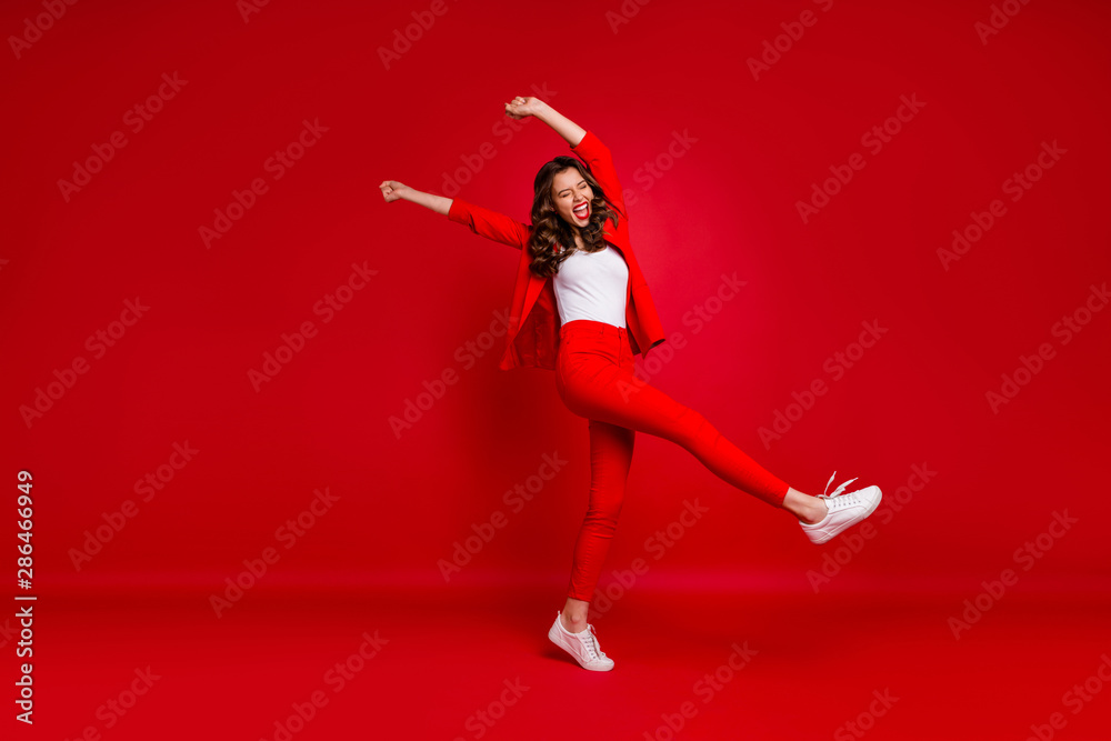 Full length photo of cheerful lady with her eyes closed screaming yeah raising fists celebrating victory isolated over red background