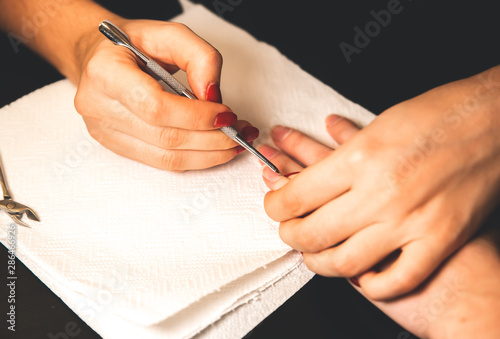 Woman is making a manicure. Salon procedures at home. Beautiful hands and nails.