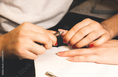 Woman is making a manicure. Salon procedures at home. Beautiful hands and nails.