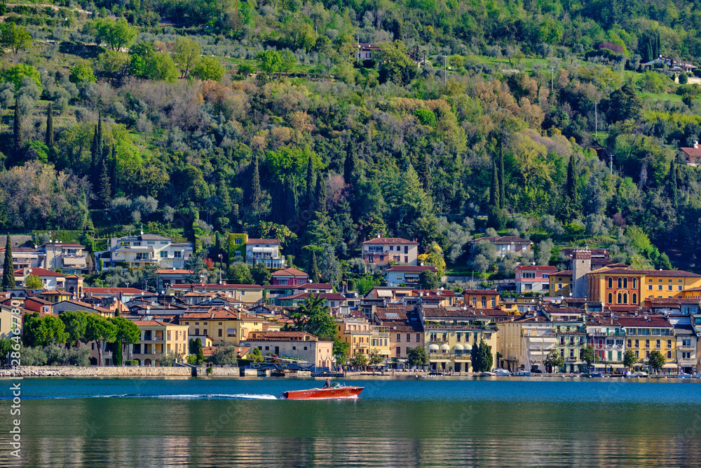  Panoramic view of the center of Salo on Lake Garda, Italy. Reflections of city buildings by the water .