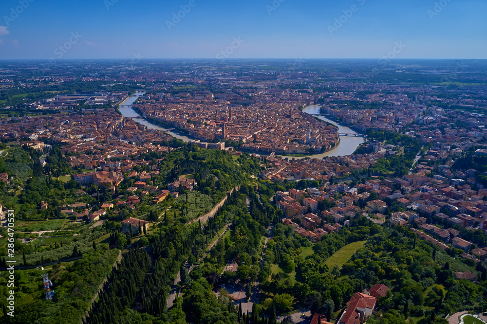 Adige river and fortified medieval castle of Castelvecchio. Aerial drone panoramic photo from  city of Verona. Verona, Italy.