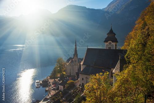 Autumn morning scenery of famous Hallstatt mountain village with lake and Alps mountains on background