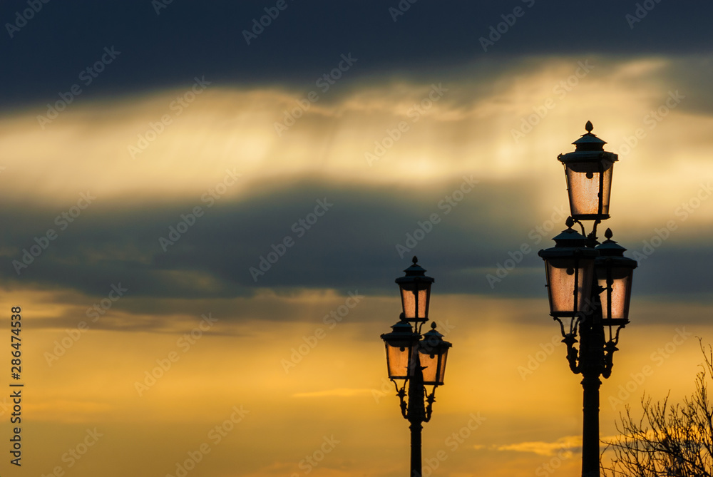 Old traditional Venice street lamps at sunset in a romantic and unique atmosphere (with copy space)