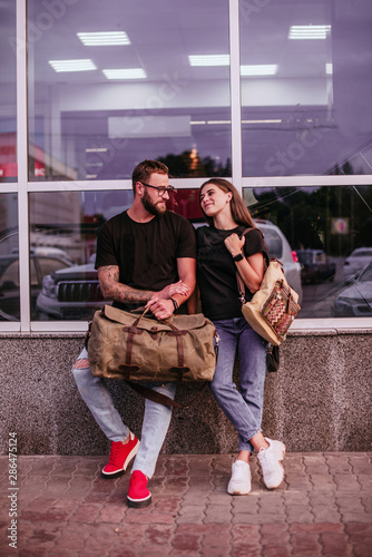Close up. Man with leather bag and woman with textile backpack. Fashion, trendy bags
