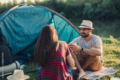 friends having coffee or tea on camping by the river