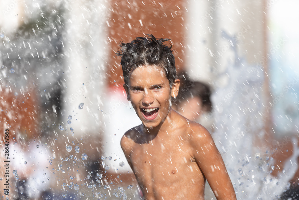 Fototapeta premium Happy children playing in a water fountain