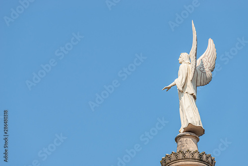 Statue of winged angel at Evangelical church Saint Nikolai at sunset and blue sky, Potsdam, Germany