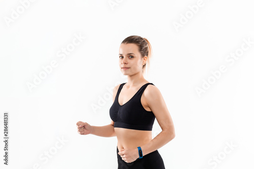 Young sporty blond woman in a black sportswear running isolated over white background © ianachyrva
