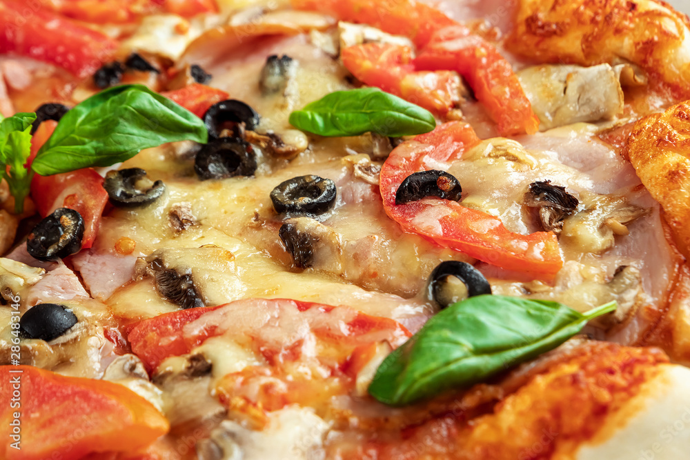 Pizza on a wooden background with ham, olives, tomatoes and green basil. Itolyan cuisine, copy space. Pizza on a wooden background with ham, olives, tomatoes and green basil. Itolyan cuisine, copy space.