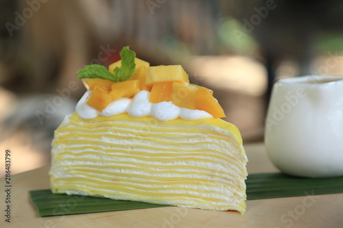Mango fruit crape cake with fresh mango piece on top.